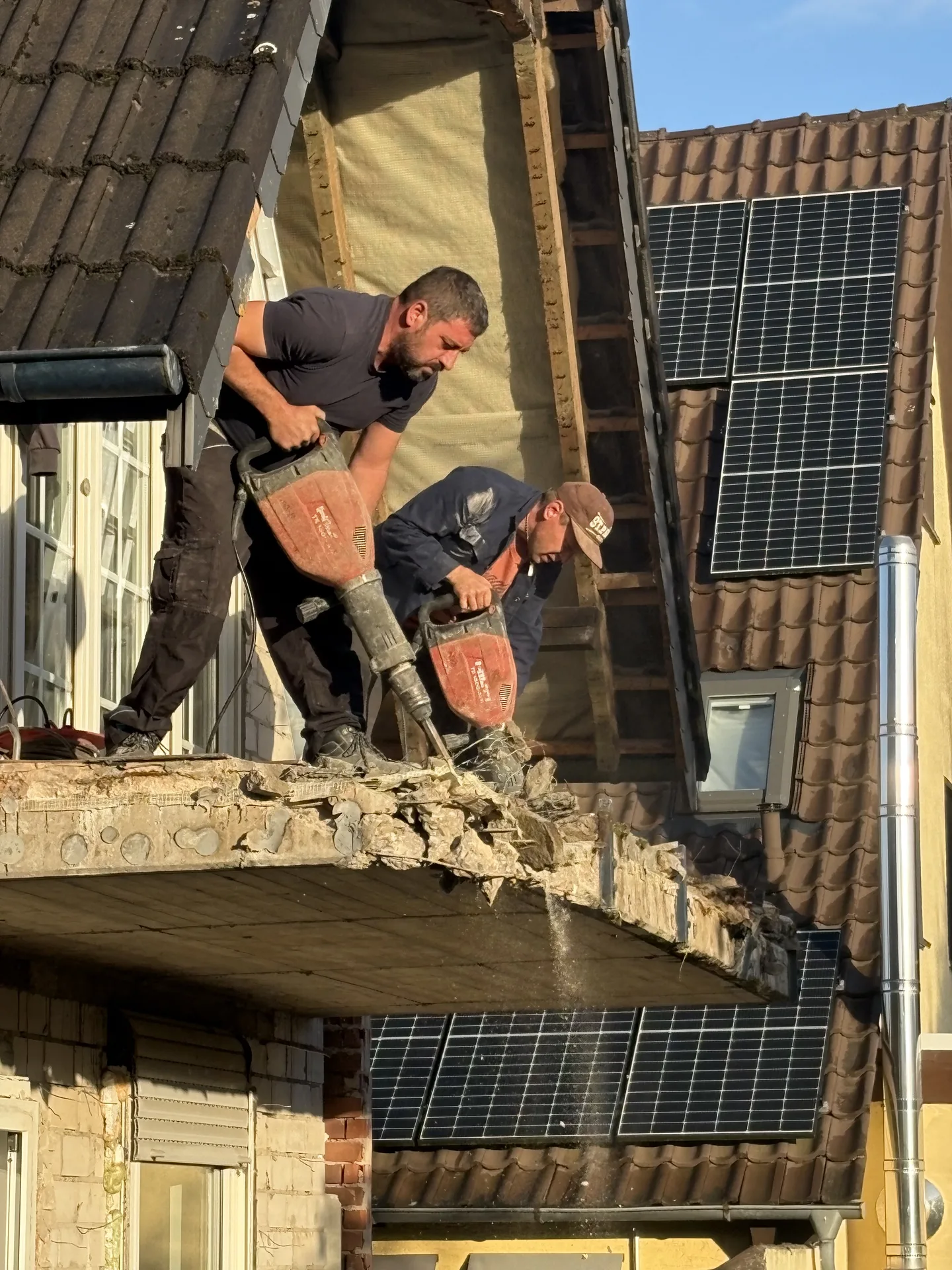 Mitarbeiter beim manuellen Rückbau an der Dachkante