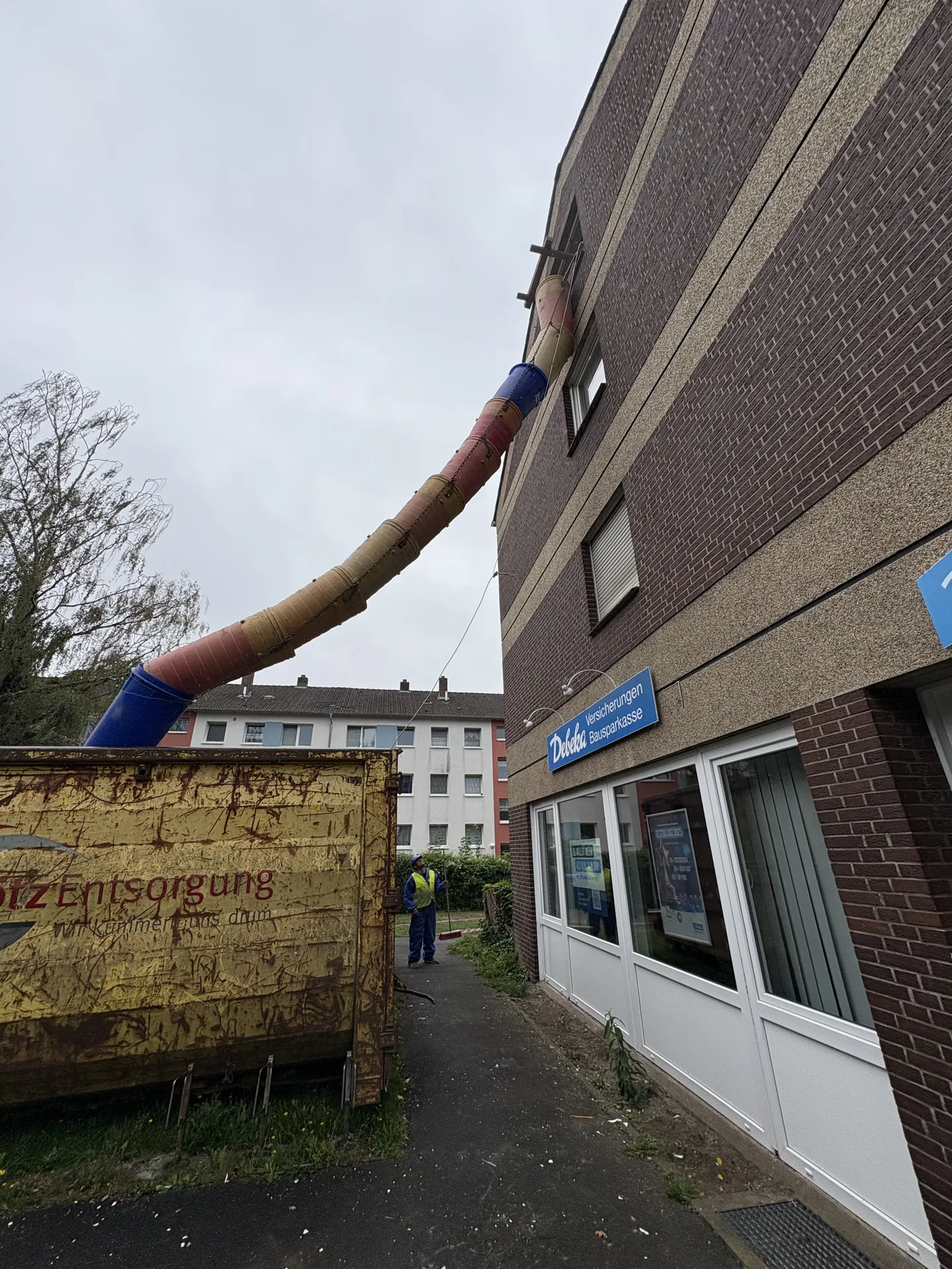 Schuttrutsche führt Bauschutt in einen Container